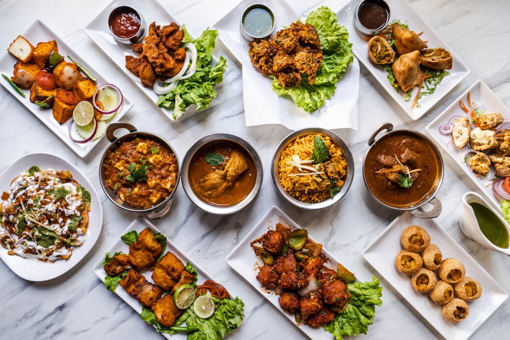 Flavorful Fiesta of Pakistan - an overhead view of dishes presented on white plates, highlighting vibrant colors and rich textures.