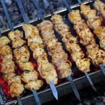 Delicious chicken kebabs grilling over hot coals, showcasing rich flavors and succulent textures.